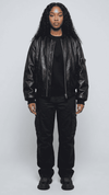 Front shot of a premium black leather bomber jacket from Jackero, showcasing the classic ribbed collar, waist hem, and a smooth silver front zipper.