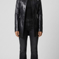 Front full-length view of premium black leather trench coat showcasing a sleek double-breasted button layout and structured matching waist belt.