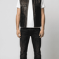 Regular fit men's black leather gilet displaying clean lines, functional front pockets, and a comfortable tailored alignment.