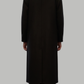 Full-length view of a sophisticated black long wool coat paired with formal attire.