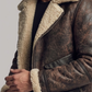 Close-up of the rugged distressed leather finish and soft cream shearling details on a brown flight jacket.