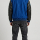 Detailed view of the athletic striped rib-knit collar, cuffs, and waistband on a premium blue suede varsity jacket.