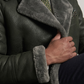 Man wearing a dark grey coat with fur, white shirt, and patterned tie.