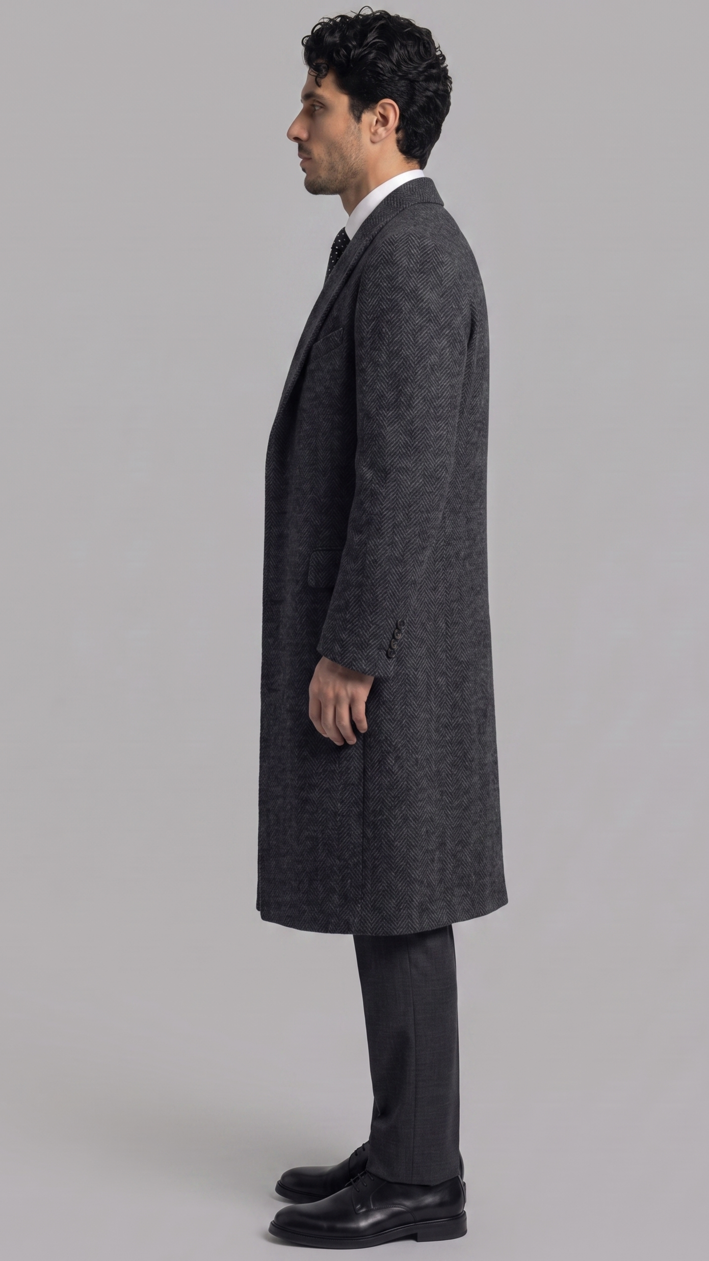 Heavy-duty charcoal grey wool overcoat layered elegantly over a casual sweater, designed for cold weather warmth.