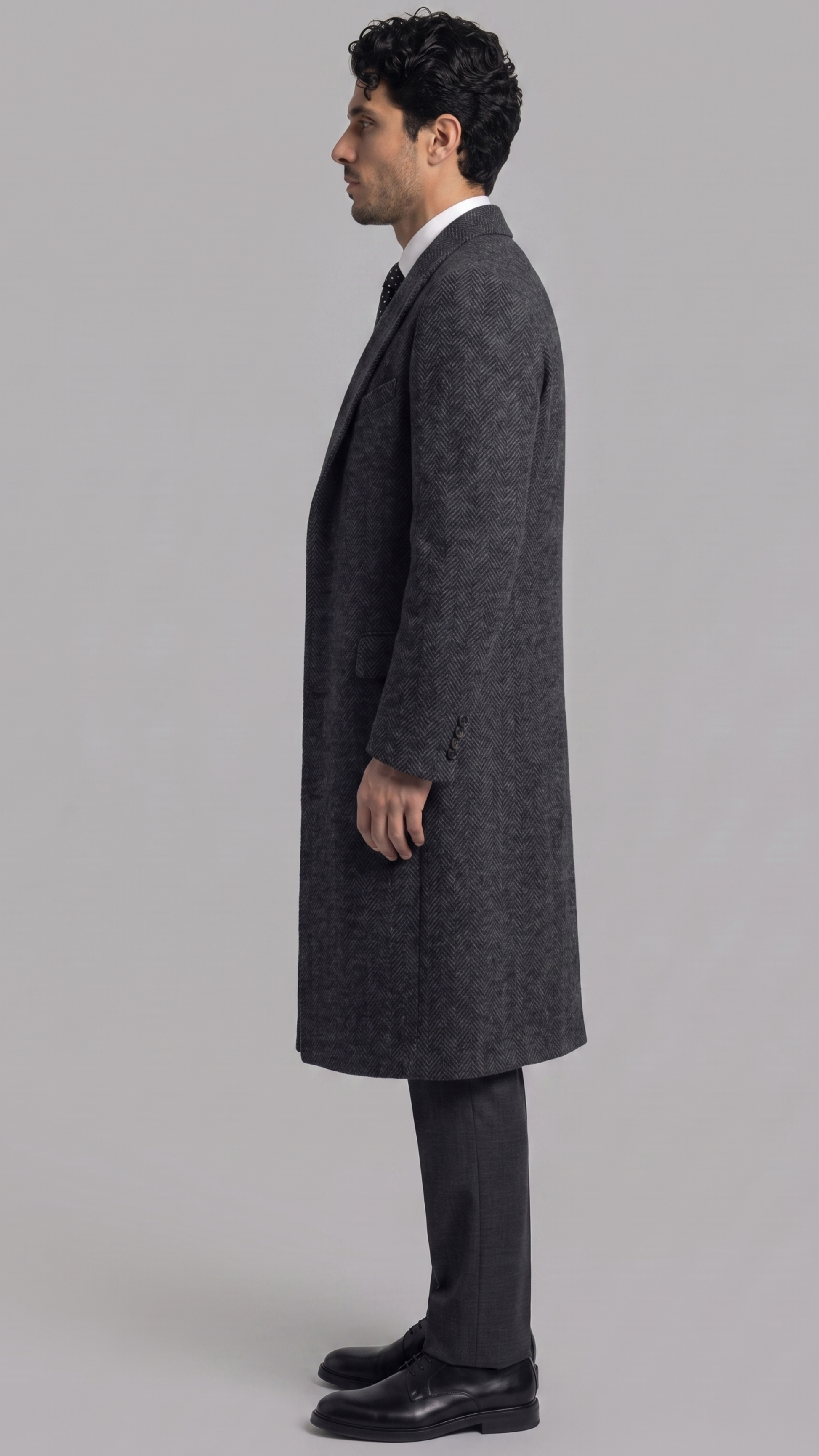 Heavy-duty charcoal grey wool overcoat layered elegantly over a casual sweater, designed for cold weather warmth.