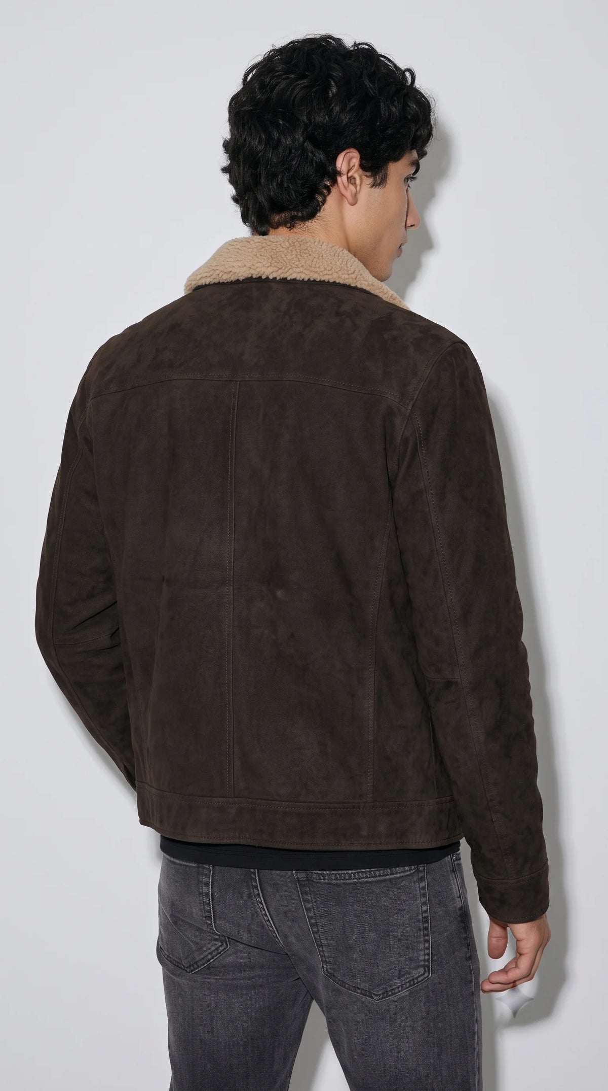 This cocoa-brown genuine suede winter jacket combines a soft, textured exterior with a plush shearling interior designed for comfortable cold-weather layering. The warm cream lining, clean zip fastening and substantial collar give the jacket a cosy yet structured appearance, suitable for winter wardrobes, casual weekend outfits and understated rugged menswear.