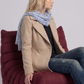 Women's sophisticated fashion showcasing a minimalist long-line cream cotton coat styled for a sharp look.