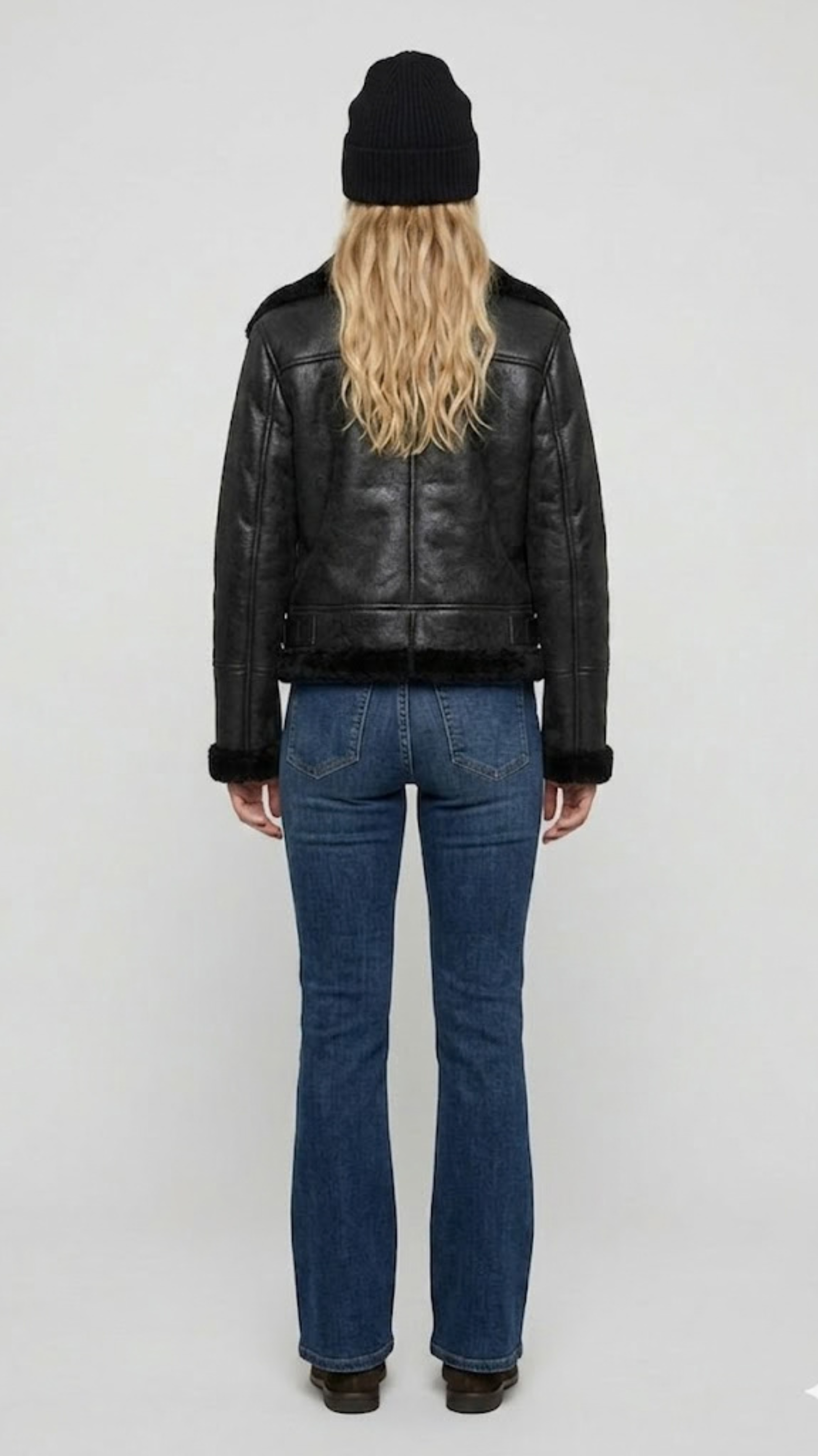 Rear view of the black leather shearling jacket showing the seamless stitching and comfortable heavy winter fit.