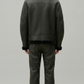 a structured dark black leather winter coat with a prominent shearling neckline.