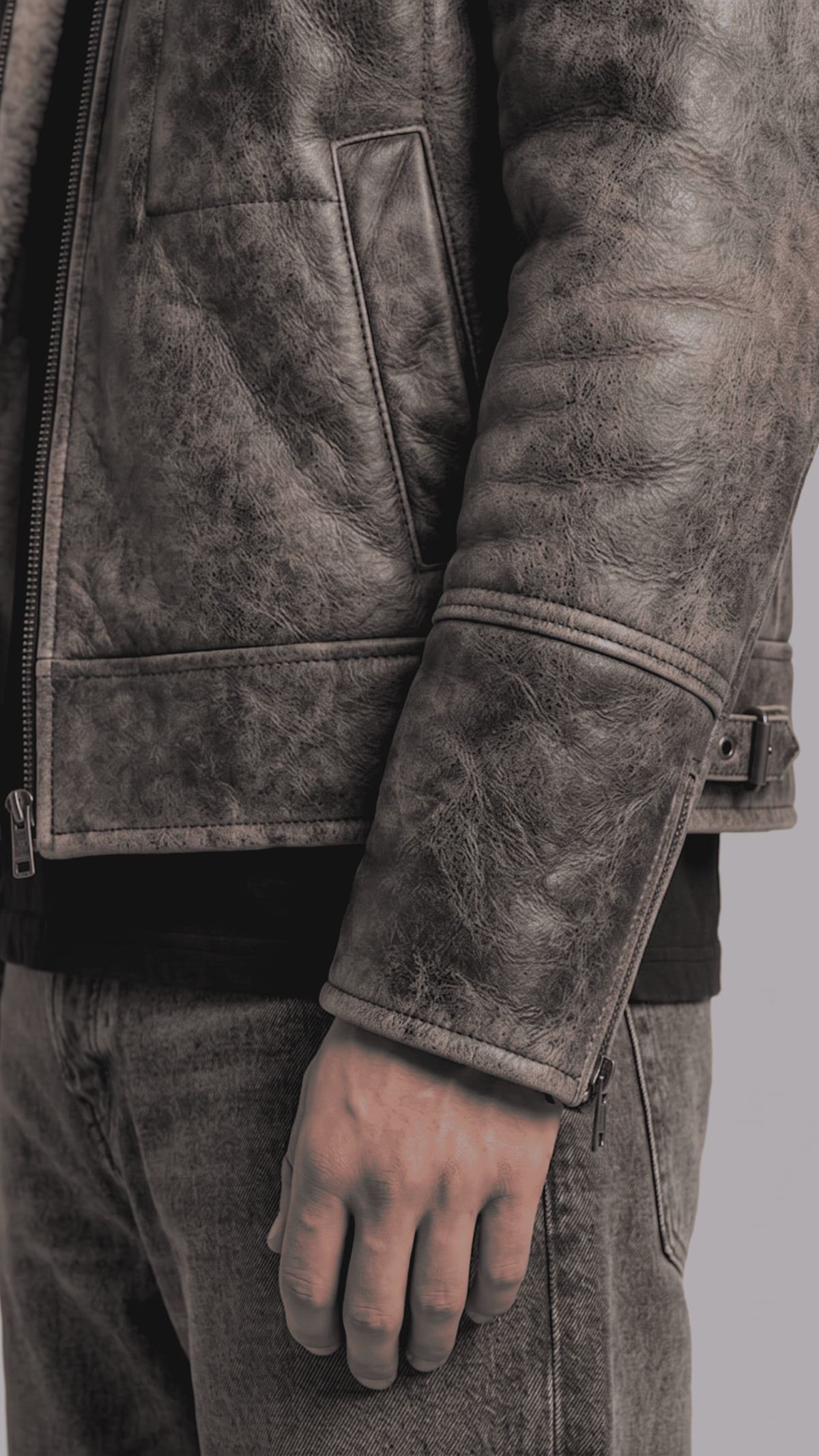 Close-up of the rugged distressed leather texture in dark grey with soft white fur lining details.