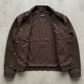 Brown canvas jacket on a gray concrete surface