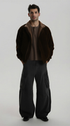 premium dark brown suede jacket with a matching soft brown shearling collar, standing against a clean grey background.