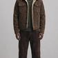 A dark chocolate brown suede trucker jacket featuring a plush cream shearling collar.