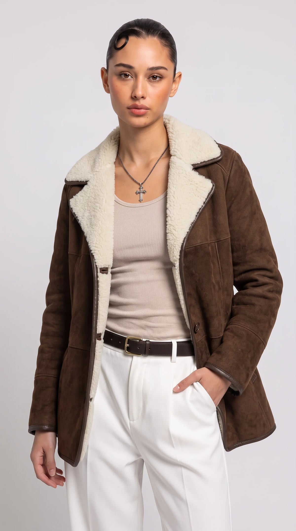 Women's dark chocolate-brown genuine suede aviator coat with oversized cream faux-shearling lapels, a plush contrasting interior, button-front closure and dark-edged seams, styled with a beige ribbed top and tailored ivory trousers for refined winter luxury fashion.