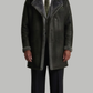 Full body shot of a man wearing a dark grey long leather coat with luxurious faux shearling lining.