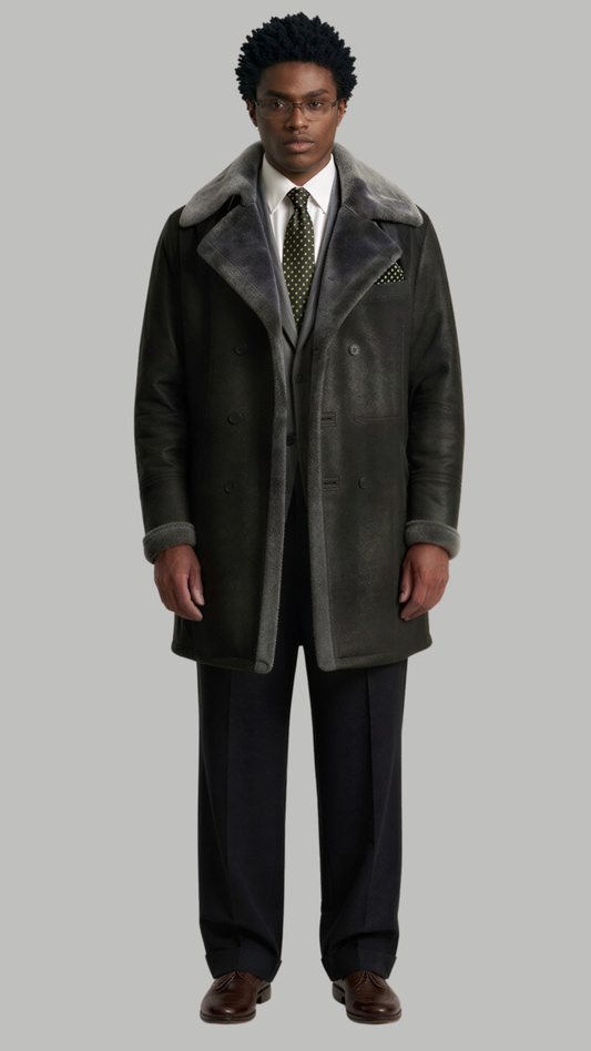 Full body shot of a man wearing a dark grey long leather coat with luxurious faux shearling lining.
