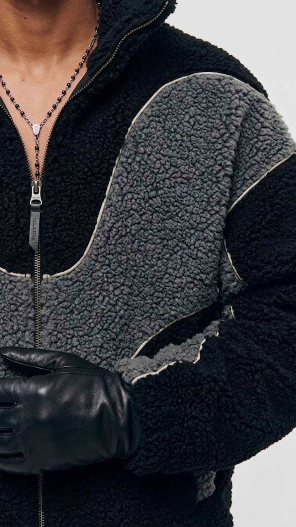 Close-up shot of full front metal zipper hardware and high stand-up neck placket on grey Y2K wool jacket.
