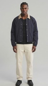 Front view studio catalog photo of a model styling the Jackero dark navy blue cotton coach jacket with a classic collar and visible snap button closures.