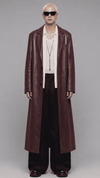 Full-length front view of model wearing an elegant dark red vine leather trench coat with a waist belt and button closure
