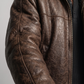 Close-up detail highlighting the smooth dark brown leather panels paired with thick, soft black shearling on the lapels