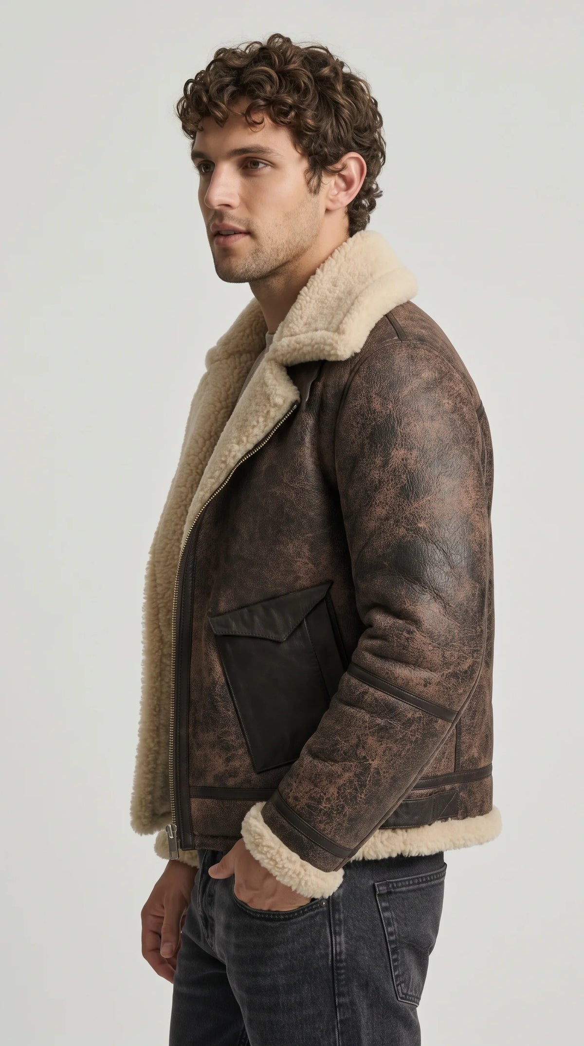 Distressed chocolate-brown leather aviator bomber with an off-centre silver zipper, contrasting dark leather pocket, reinforced sleeve seams and exposed cream faux-shearling edges, delivering a rugged biker-inspired aesthetic for contemporary cold-weather outfits.
