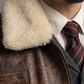 Man wearing a brown leather jacket with a cream fur collar.