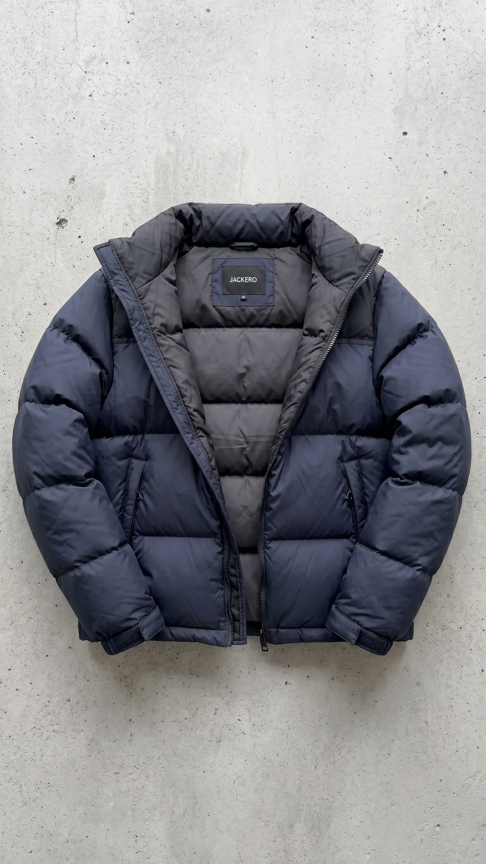 Detailed look at the protective high collar and cuffs of a navy blue quilted puffer jacket.