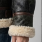 Detailed macro shot highlighting the rich texture of the soft faux cream fur lining against the premium black leather.