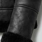 Close-up detail of the plush, soft faux shearling lining and collar on a heavy-duty black leather winter jacket.
