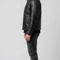 classic snap-button collar, lapel construction, and zippered chest pockets of a black leather biker jacket.