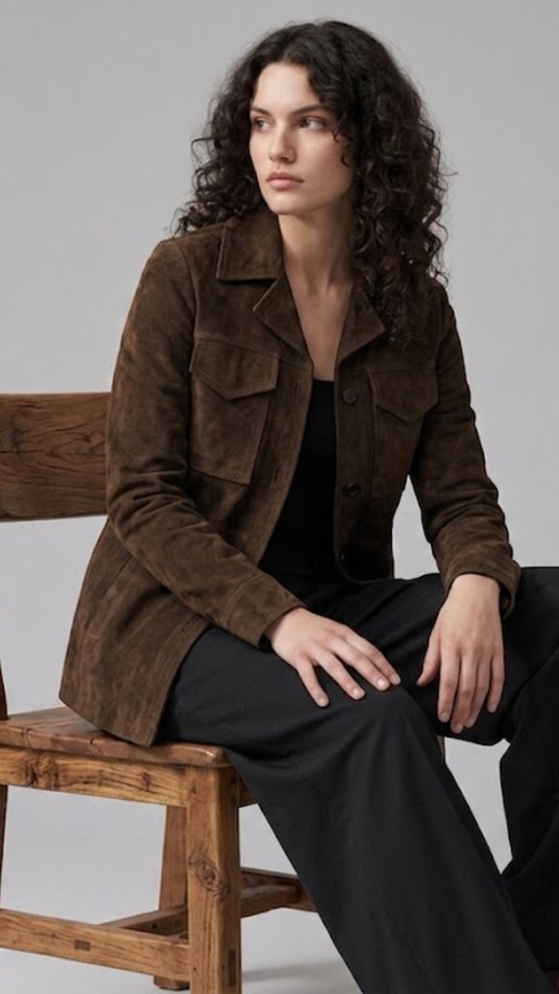 Tailored dark brown suede utility jacket with structured pointed collar and dark buttons.