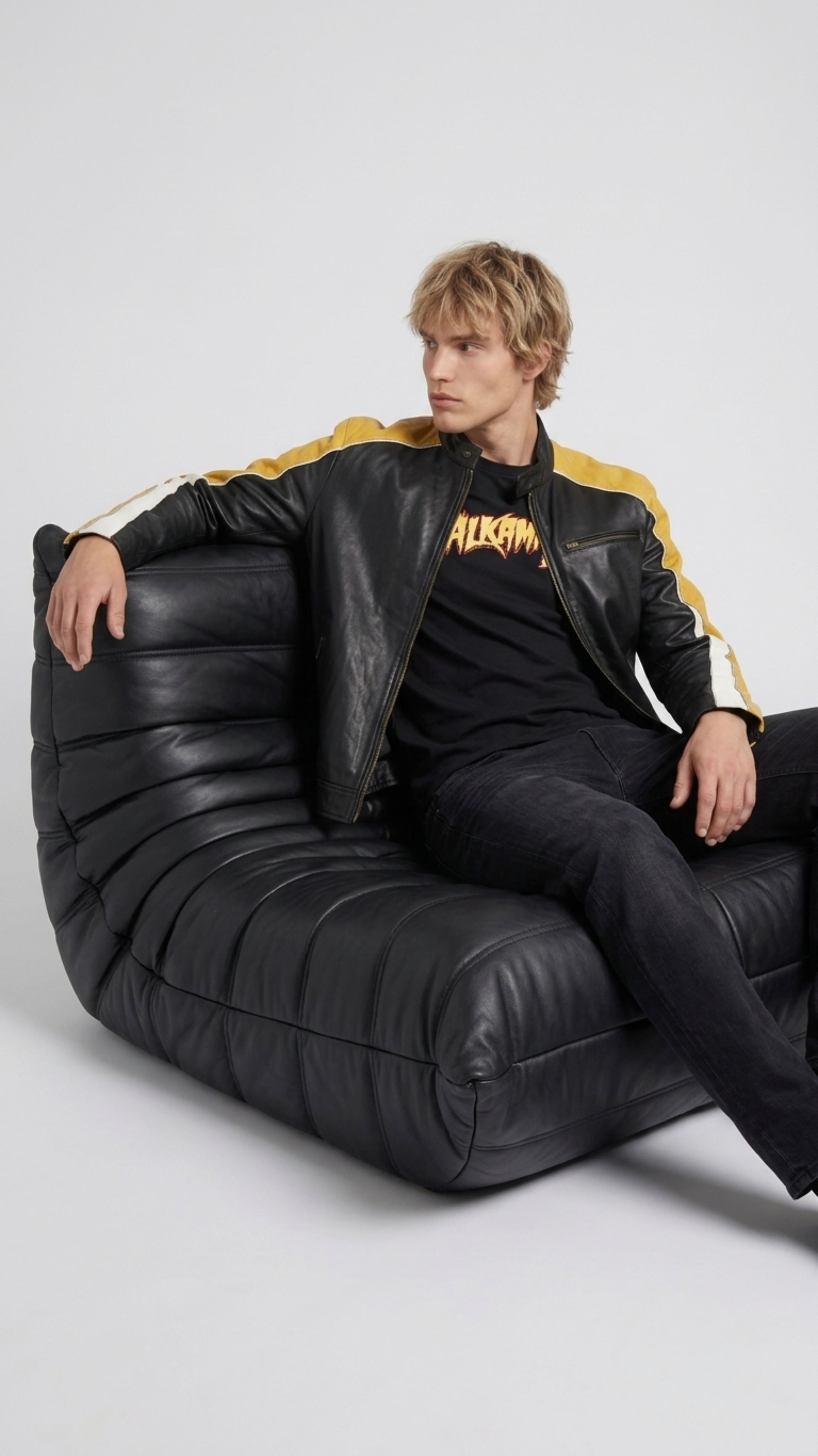 Men's contemporary racing fashion showcasing a structured yellow, black, and white leather biker jacket with speed stripes.