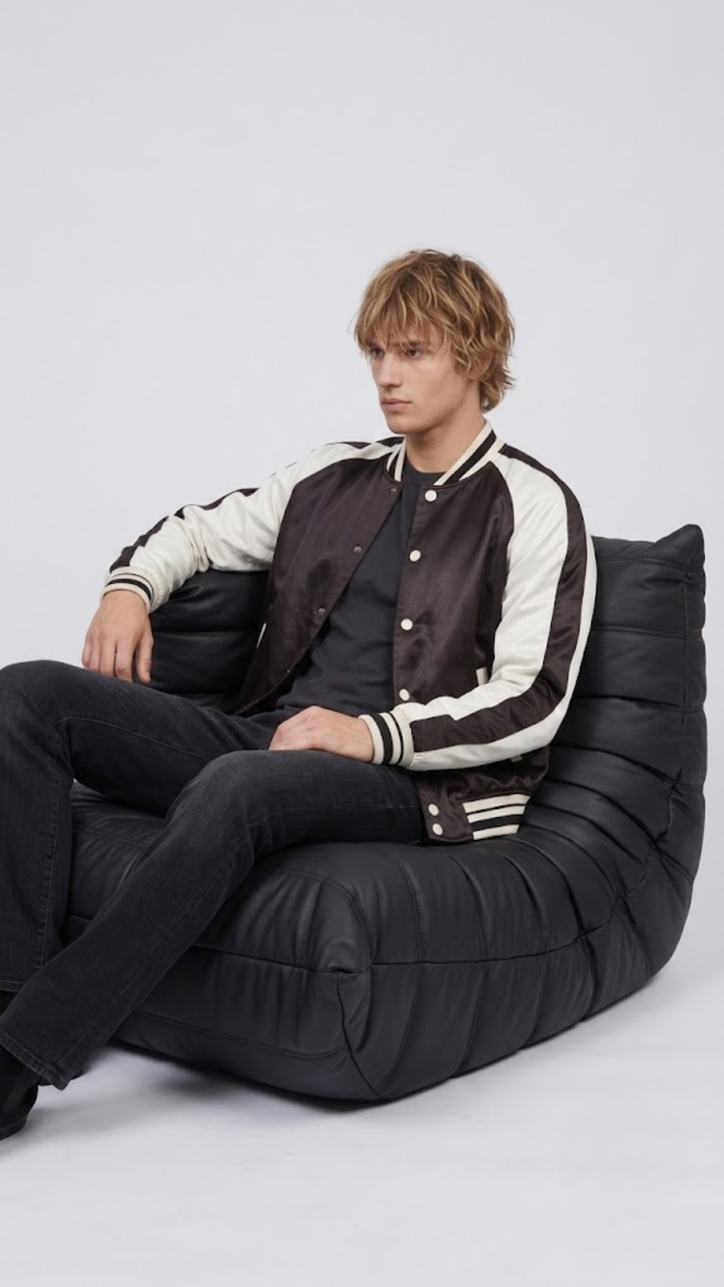 Men's contemporary casual fashion featuring a structured black and white varsity jacket styled for an iconic collegiate street look.