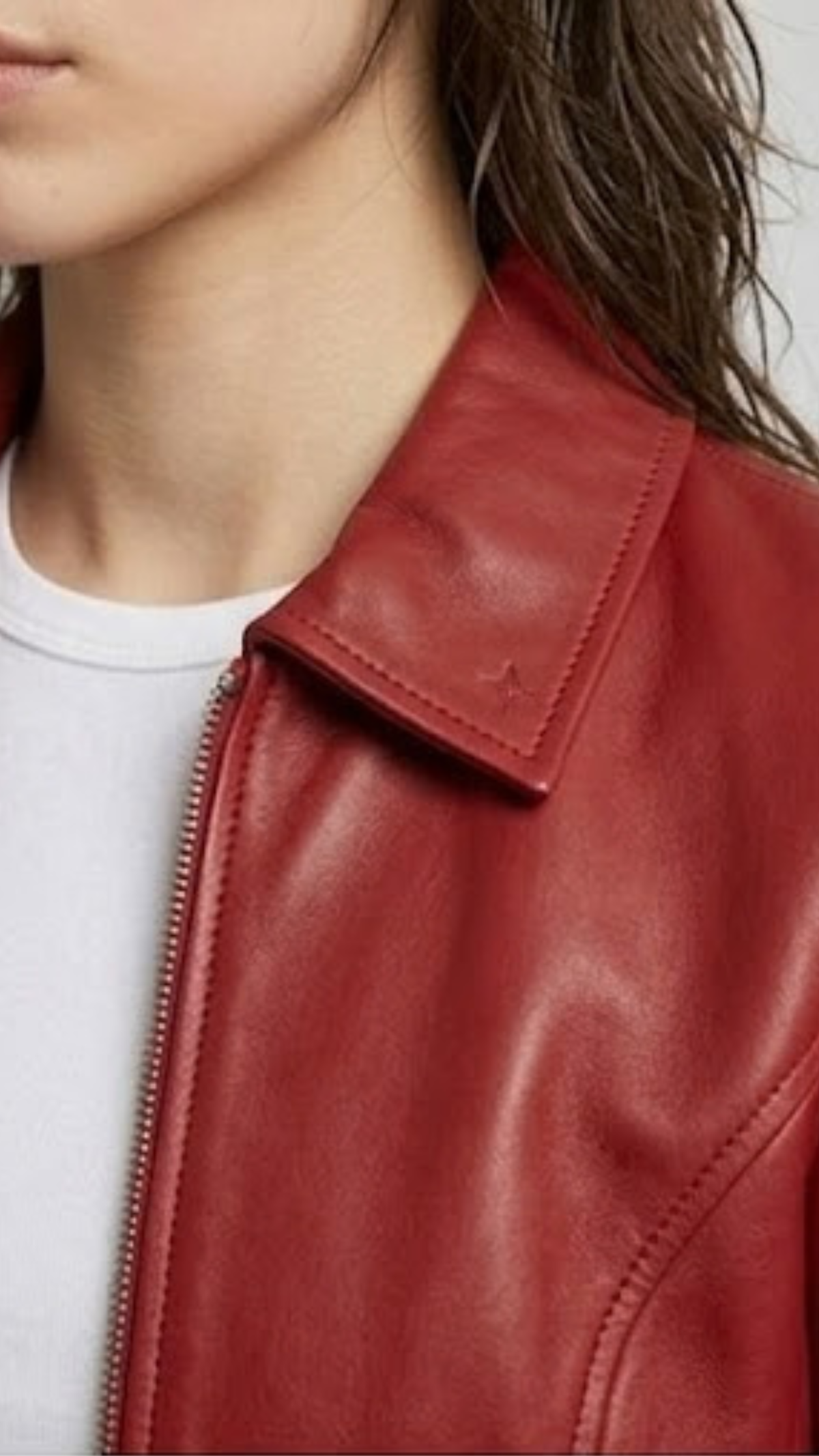 Close-up micro detail focusing on the premium texture of the red genuine leather material and high-quality metallic zipper tracks.