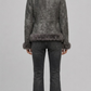 Model wearing a JACKERO fitted grey fur-trimmed shearling coat paired with a white crop top and high-waisted black flare jeans.