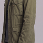 Close-up shot highlighting the lightweight, durable woven fabric and premium snap buttons on an olive green utility jacket.