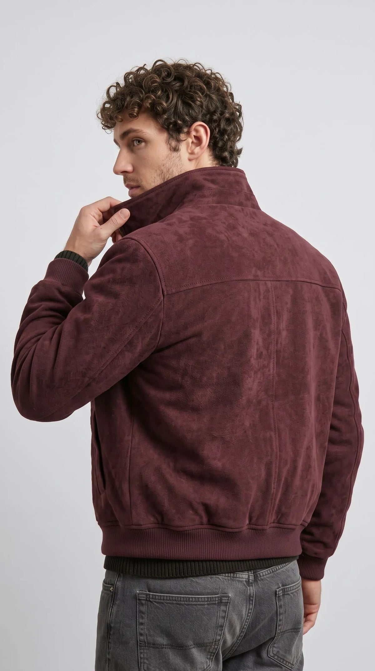 Oxblood red cotton Harrington jacket with a defined shoulder yoke, clean tonal panel seams and a gathered rib-knit hem, delivering a structured waist-length silhouette with understated heritage-inspired menswear appeal.