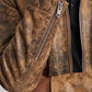 Brown leather jacket with a zipper on a plain background