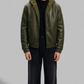 Jackero premium dark green leather bomber jacket featuring a plush white shearling-lined hood and sturdy zip closure.