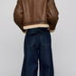 Women's stylish brown cropped aviator jacket with white shearling trim, styled for a modern winter streetwear look.