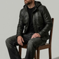 Edgy lifestyle streetwear presentation featuring a black leather motorcycle hoodie jacket styled for an active lifestyle.