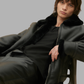 Model wearing a black shearling leather aviator jacket with front zip closure.