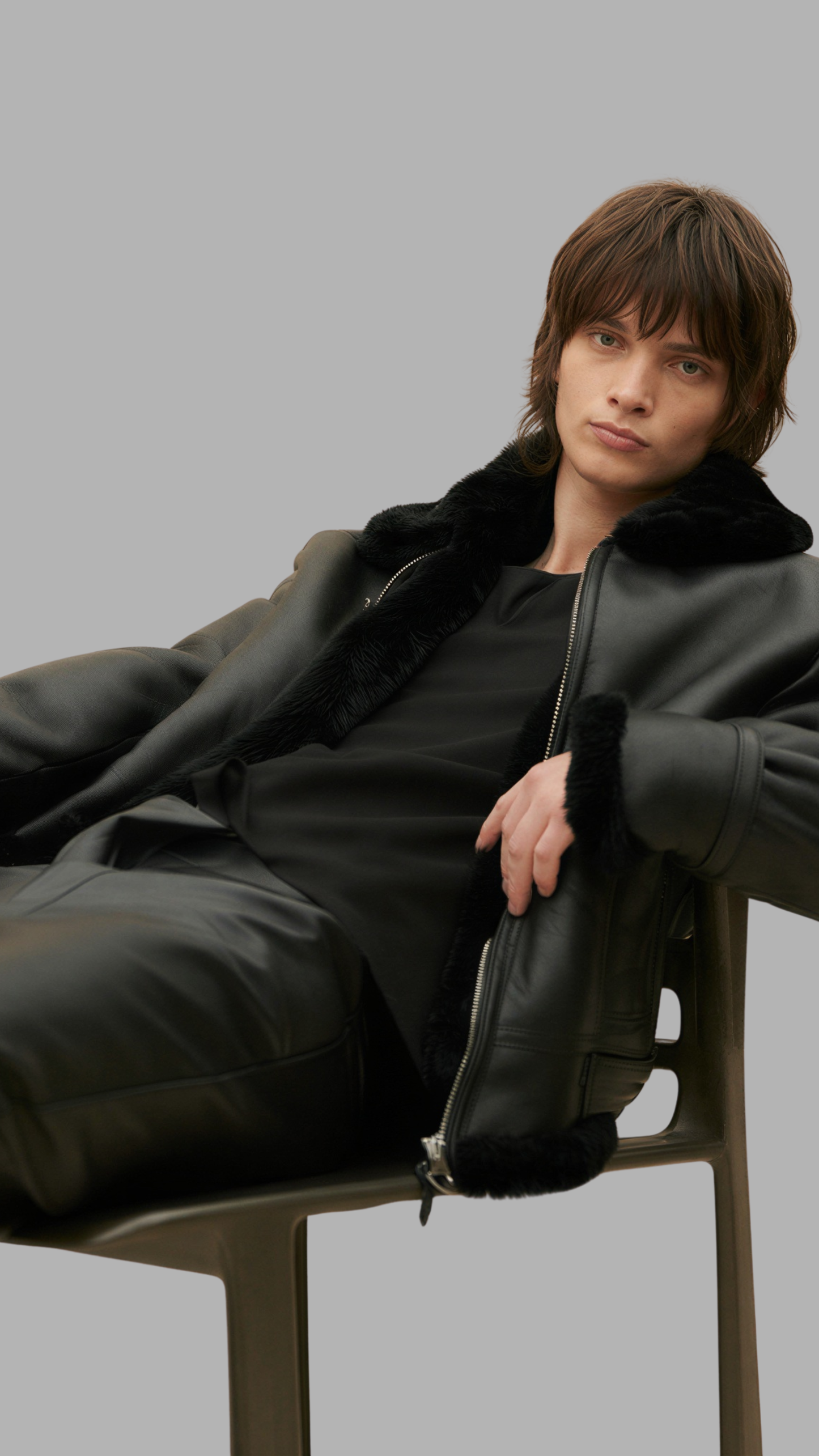 Model wearing a black shearling leather aviator jacket with front zip closure.