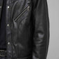 Detailed view of the structured minimal collar, metallic zipper pull, and clean seam lines on a pitch-black leather coat.