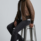 Urban street fashion lookbook image showcasing a men's heritage outerwear styling focused on the luxury dark chocolate brown leather bomber jacket.