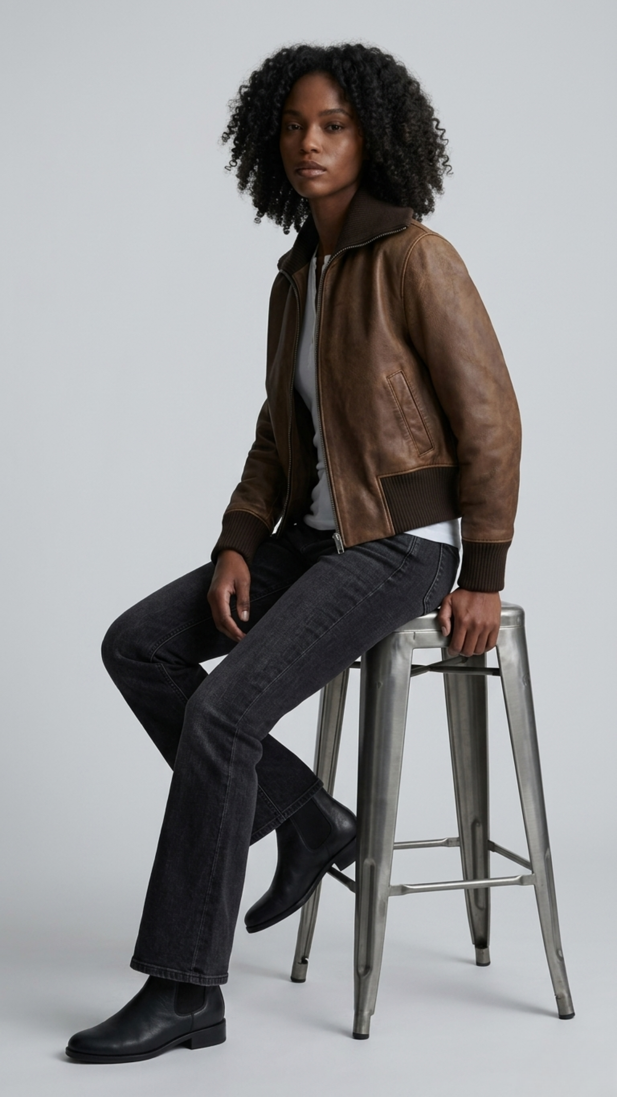 Urban street fashion lookbook image showcasing a men's heritage outerwear styling focused on the luxury dark chocolate brown leather bomber jacket.