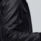 Macro detailed focus capture showing the rich grain sheen of the black genuine leather jacket and tactile adjustable hood details.