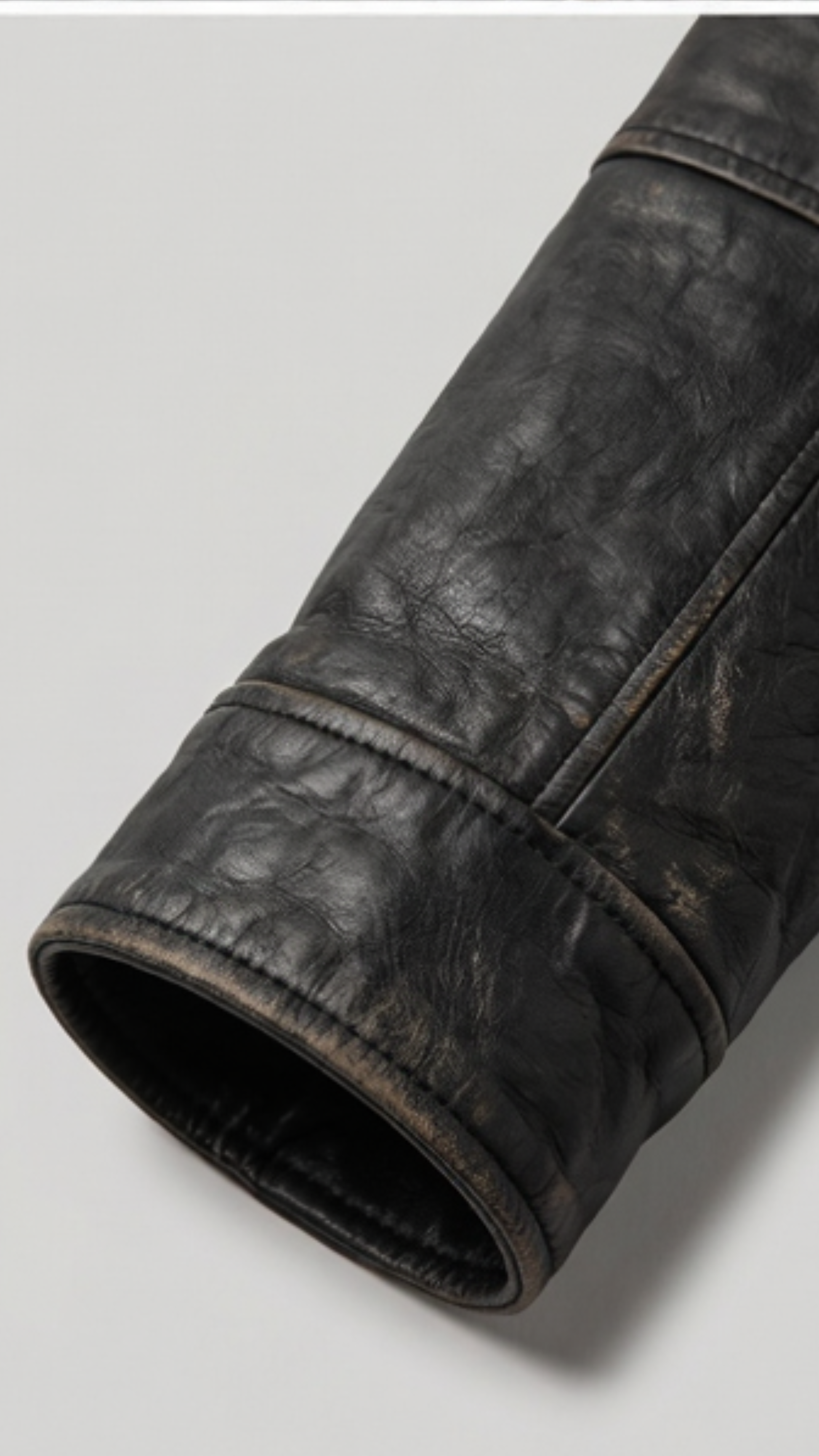 Close-up micro detail focusing on the premium zippered chest pockets and ribbed cuffs of a black leather hooded coat.