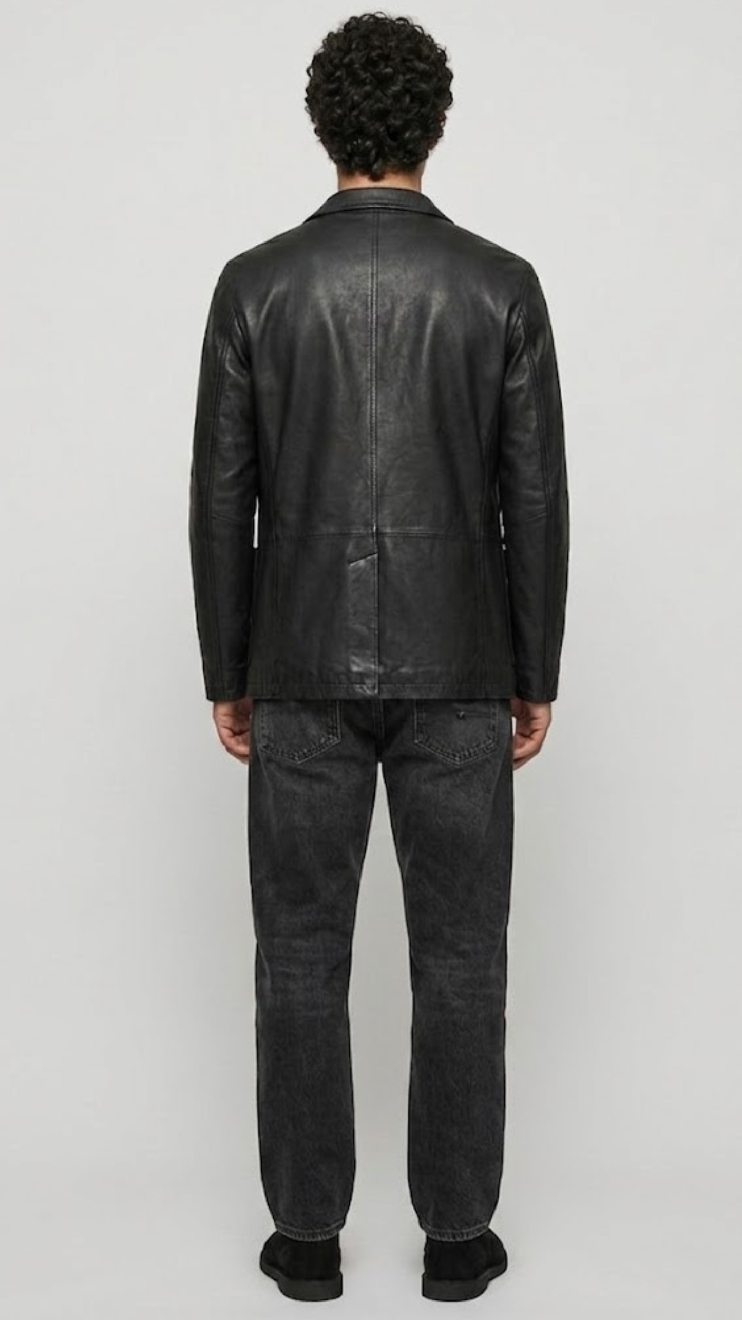 back-angle profile of a regular fit black leather dinner jacket displaying smooth drape and premium leather material quality.