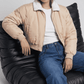 Women's contemporary high-fashion presentation featuring a sleek cream cotton silk short jacket styled effortlessly for an upscale casual look.